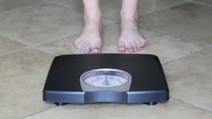 stock-footage-a-woman-weighing-herself-on-a-bathroom-scale